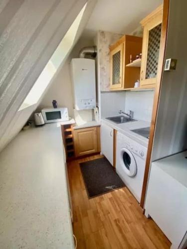 une cuisine avec un évier et une machine à laver dans l'établissement Plage et Golf !, à Houlgate