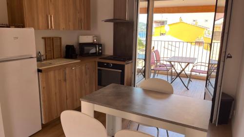 Il dispose d'un balcon et d'une cuisine avec une table et des chaises. dans l'établissement forcioli conti T2 tout confort, à Ajaccio