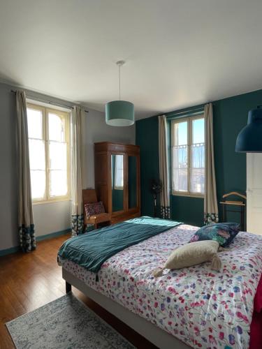 - une chambre avec un grand lit, des murs verts et des fenêtres dans l'établissement Aux portes des iles, à Saint-Just