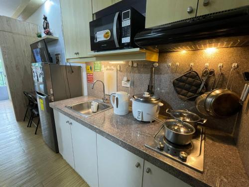 a kitchen counter with pots and pans on it at SMDC GRACE RESIDENCIES in Manila