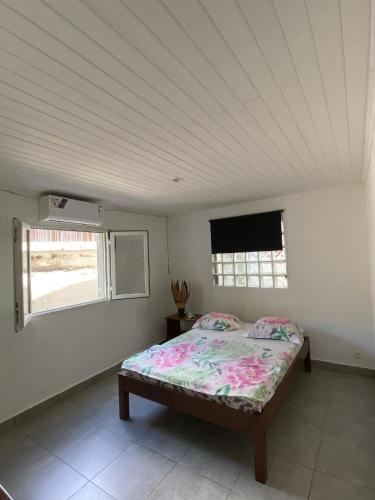 a bedroom with a bed and a tv on the wall at Appartements Tsy kivy in Hell-Ville