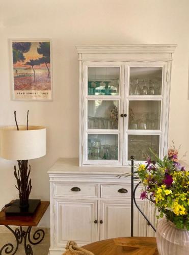 a white hutch with glass doors in a room at Maison vue mer sur les Îles d'Or in Le Lavandou