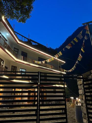 a building with a fence with flags on it at Byway, Kasol in Manīkaran