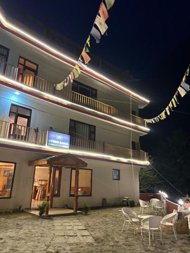 a building with tables and chairs in front of it at night at Byway, Kasol in Manīkaran