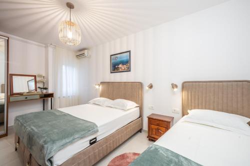 a bedroom with two beds and a chandelier at Guest House Medin in Petrovac na Moru