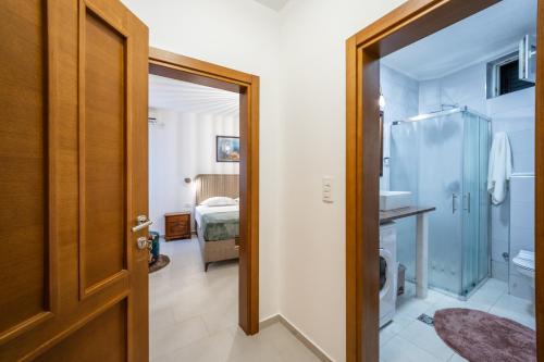 a bathroom with a shower and a door to a bedroom at Guest House Medin in Petrovac na Moru