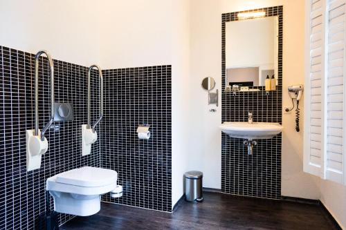 a bathroom with a toilet and a sink at Hotel Villa Ruimzicht in Doetinchem