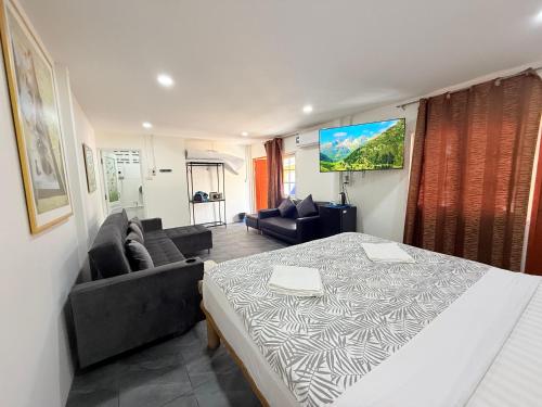 a bedroom with a bed and a living room with a couch at Harry's Beach Club in Ban Phe
