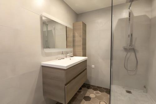une salle de bain blanche avec un lavabo et une douche dans l'établissement Paris 15 Tour-Eiffel Bd Grenelle - 2 rooms, à Paris