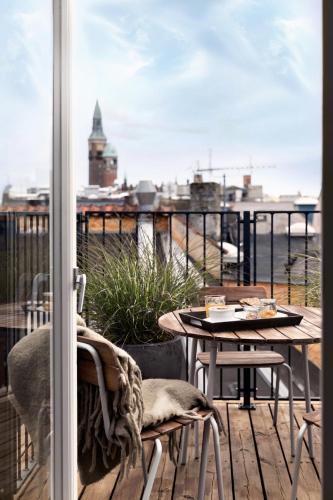 a balcony with a table and chairs and a window at Hotel SP34 in Copenhagen