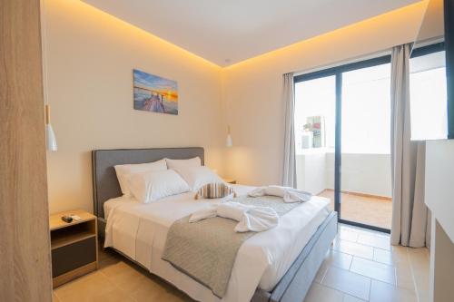 Ένα ή περισσότερα κρεβάτια σε δωμάτιο στο Blue Wave Suites - Ixia