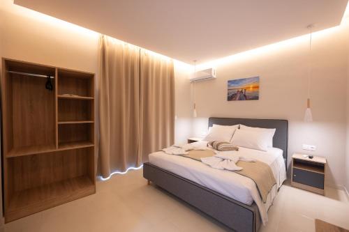 Ένα ή περισσότερα κρεβάτια σε δωμάτιο στο Blue Wave Suites - Ixia