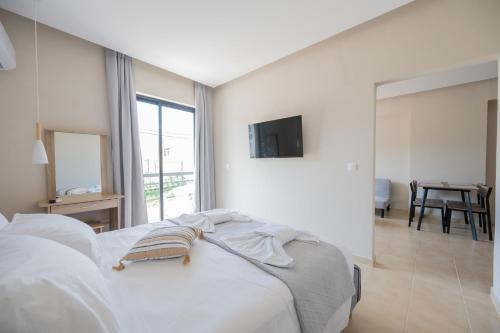 Ένα ή περισσότερα κρεβάτια σε δωμάτιο στο Blue Wave Suites - Ixia