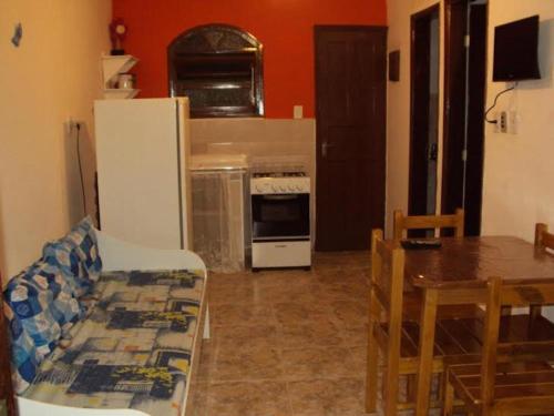 a kitchen with a table and a kitchen with a refrigerator at Chale Colonial in Ubatuba