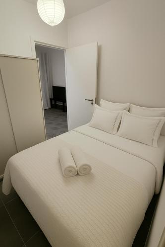 a white bed with two towels on top of it at Studio by The Sea in Limassol