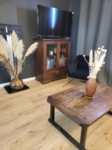 un salon avec une table basse et une télévision dans l'établissement Black and White - Joli appart à Tours, à Joué-lès-Tours