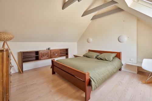 une chambre avec un grand lit dans un grenier dans l'établissement Longère de charme, Mousterlin, à Fouesnant