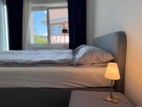 a bed with a lamp next to a window at Hegau in Sipplingen