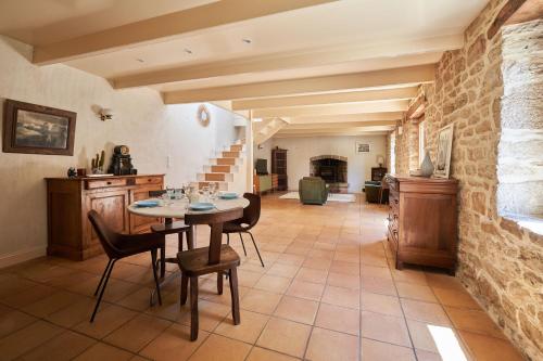 une salle à manger avec une table et des chaises et un mur en pierre dans l'établissement Longère de charme, Mousterlin, à Fouesnant