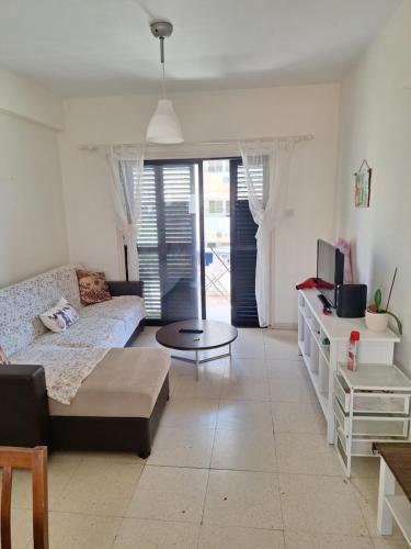 a living room with a couch and a table at Easy 2 bedroom apartment, Makenzi beach in Aglantzia