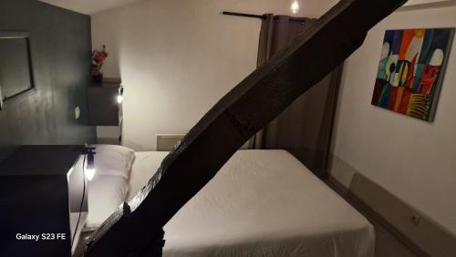 a bed in a hotel room with a black railing at T3 Cosy - 4 personnes a 5 min de Rennes in Noyal-Châtillon-sur-Seich