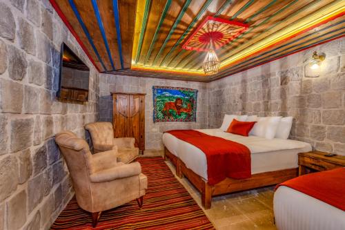 a bedroom with a bed and a chair in a room at Gala Cave Cappadocia in Goreme