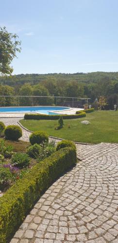 a cobblestone walkway next to a swimming pool at Ihre Auszeit am Golfplatz in Meisdorf