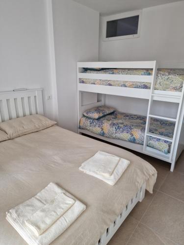 a bedroom with two bunk beds with towels on them at AURORA Apartment Shëngjin Kune in Shëngjin