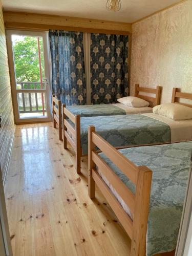 a bedroom with four beds and a window at Cottage Gageta in Ureki