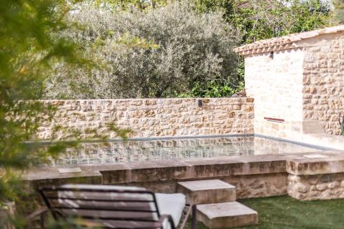 a patio with two chairs and a brick wall at Coudignac 1891 in Lagnes