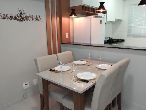 a dining room table with chairs and glasses on it at Aconchego de Espírito Santo do Pinhal in Espirito Santo Do Pinhal