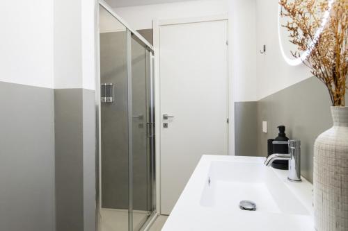 a bathroom with a sink and a glass shower at Easylife - Milano - Studio Cav 3 - Centrale in Milan