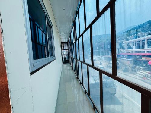 una habitación vacía con ventanas en un edificio en Kedar crown, en Ukhimath
