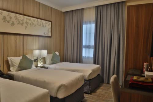a hotel room with two beds and a window at فندق ديوان الهجرة in Medina