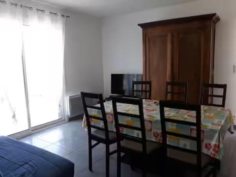 un salon avec une table, des chaises et un canapé dans l'établissement Maisons à 200 m de la plage, à Saint-Pierre-dʼOléron