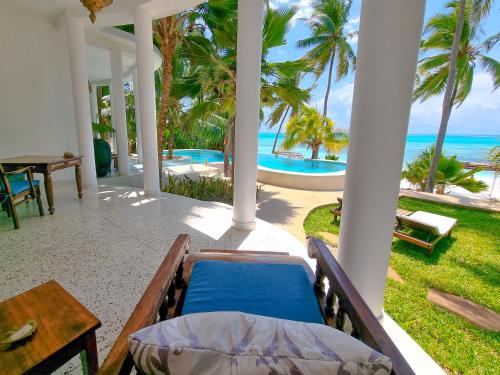 a porch with a bed and a view of the ocean at Boutique Hotel Matlai in Michamvi