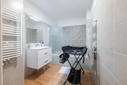 - une salle de bains blanche pourvue d'un lavabo et d'un tabouret dans l'établissement Apartment Vieil Antibes 82 m2 with secured private parking 3 Rooms, à Antibes