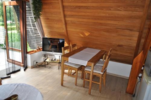 a dining room with a table and chairs and a television at Finnhütte-mit dem Gesang der Vögel erwachen in Suckow