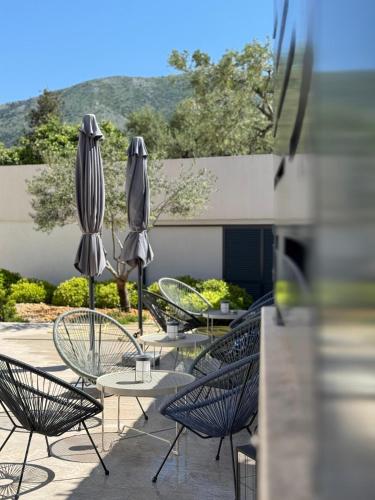 a group of tables and chairs with umbrellas at Apartments Olea in Cavtat