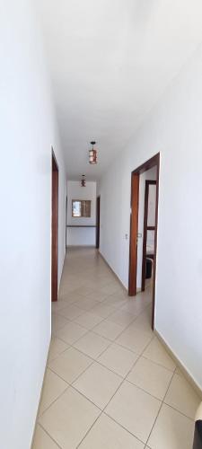 an empty hallway with white walls and a tile floor at 2 Palmat Hotel in Ksamil