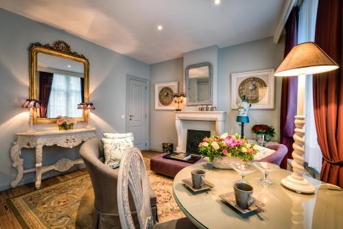 uma sala de estar com uma mesa e uma lareira em Canalside House - Luxury Guesthouse em Bruges