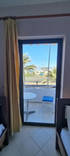 a room with a view of a patio with a table at 2 Palmat Hotel in Ksamil