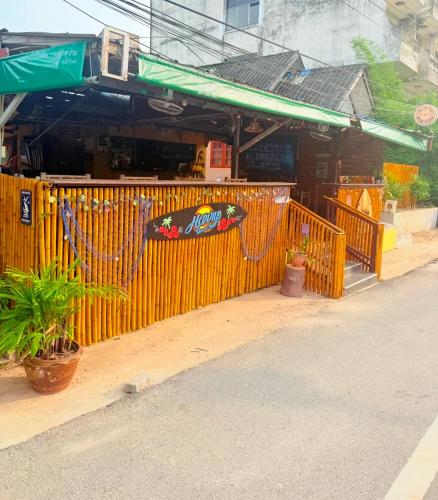 a yellow fence in front of a restaurant at Harry's Beach Club in Ban Phe