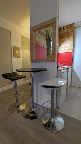 une cuisine avec deux tables et deux tabourets dans l'établissement Studio spacieux - Labronie, à Sarlat-la-Canéda