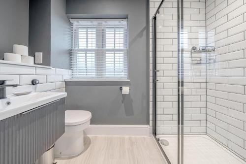 a bathroom with a toilet and a glass shower at Silver Birches by MCF in Redhill