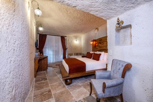 a bedroom with a bed and a chair in a room at Gala Cave Cappadocia in Goreme