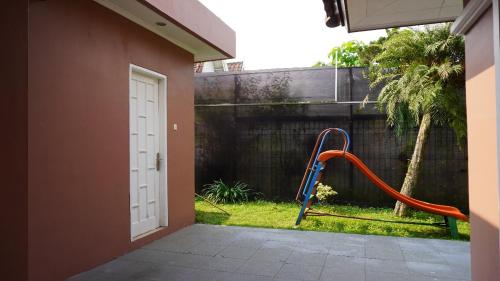 a playground in a yard next to a house at Diyar Villas Puncak M6/12 in Puncak