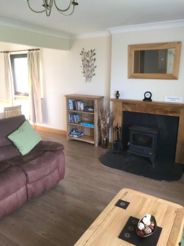 a living room with a couch and a fireplace at Ardmore Holiday Cottage in Trumpan
