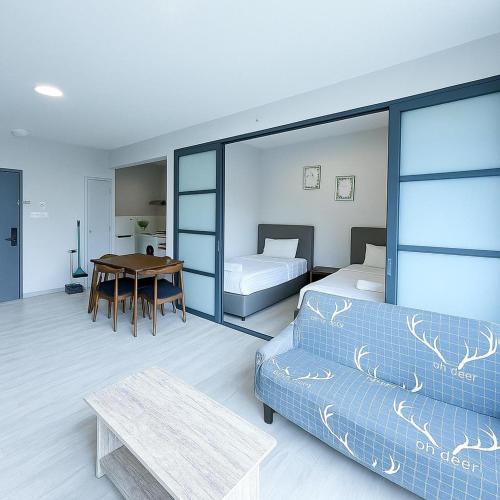 a bedroom with a bed and a table and a couch at 适合全家入住 Jesselton Quay高楼层日落景公寓 近Suria & Gaya街 Perfect for Families High-Floor Sunset Condo at Jesselton Quay Near Suria and Gaya Street in Kota Kinabalu