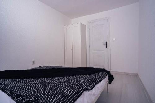 a bedroom with a bed and a white door at Студио Черно и Бяло in Sandanski